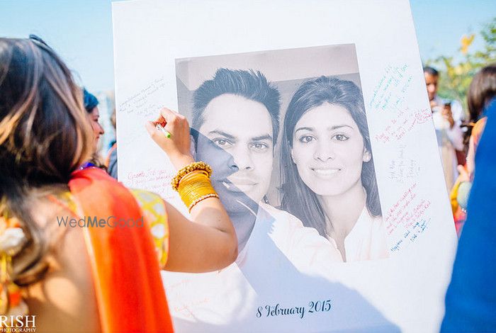 Photo of Guests sign and leave messages on a guest book which is a printed photo of the bride and groom