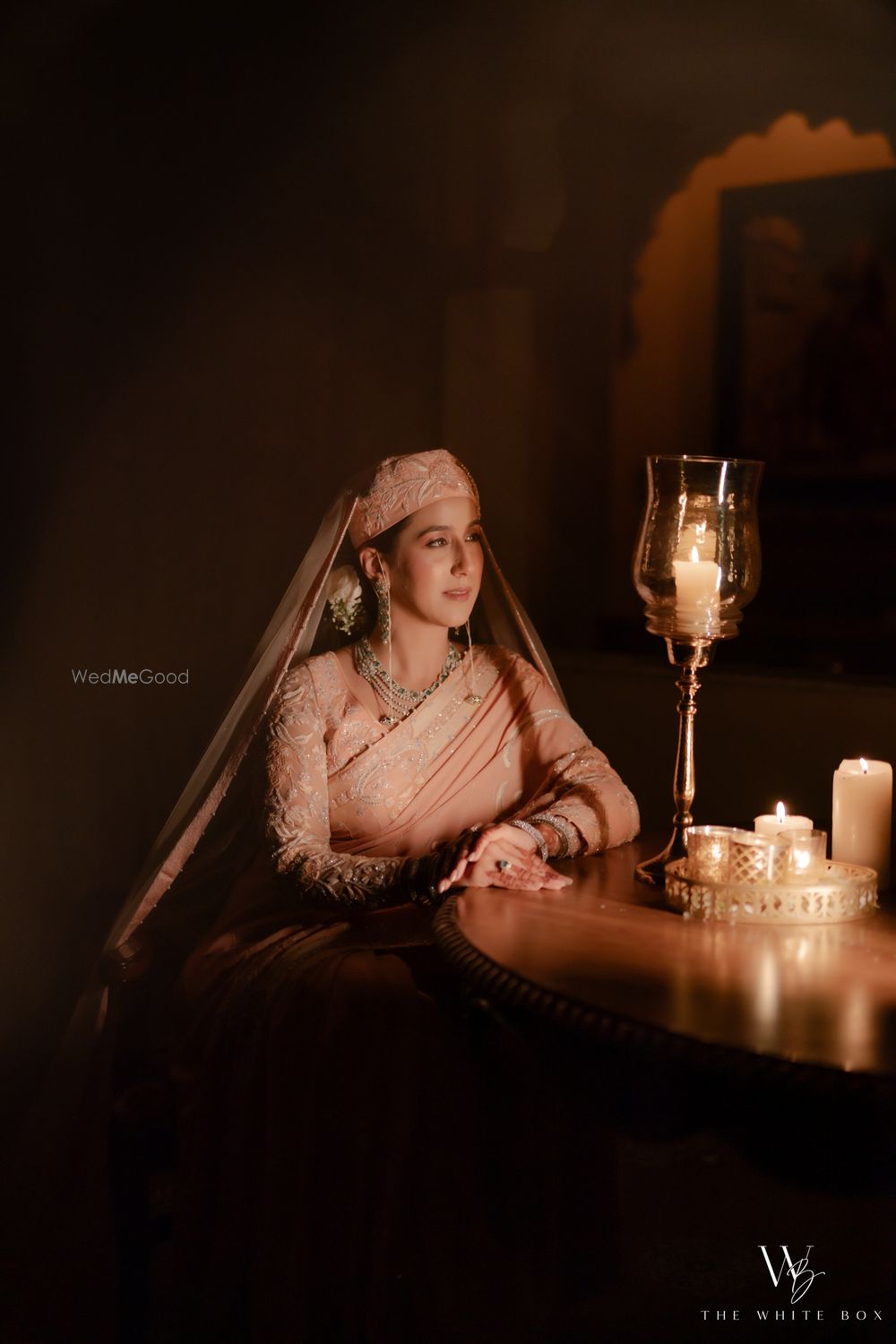 Photo of Gorgeous bridal portrait with the bride in a peach saree and headgear on her wedding day