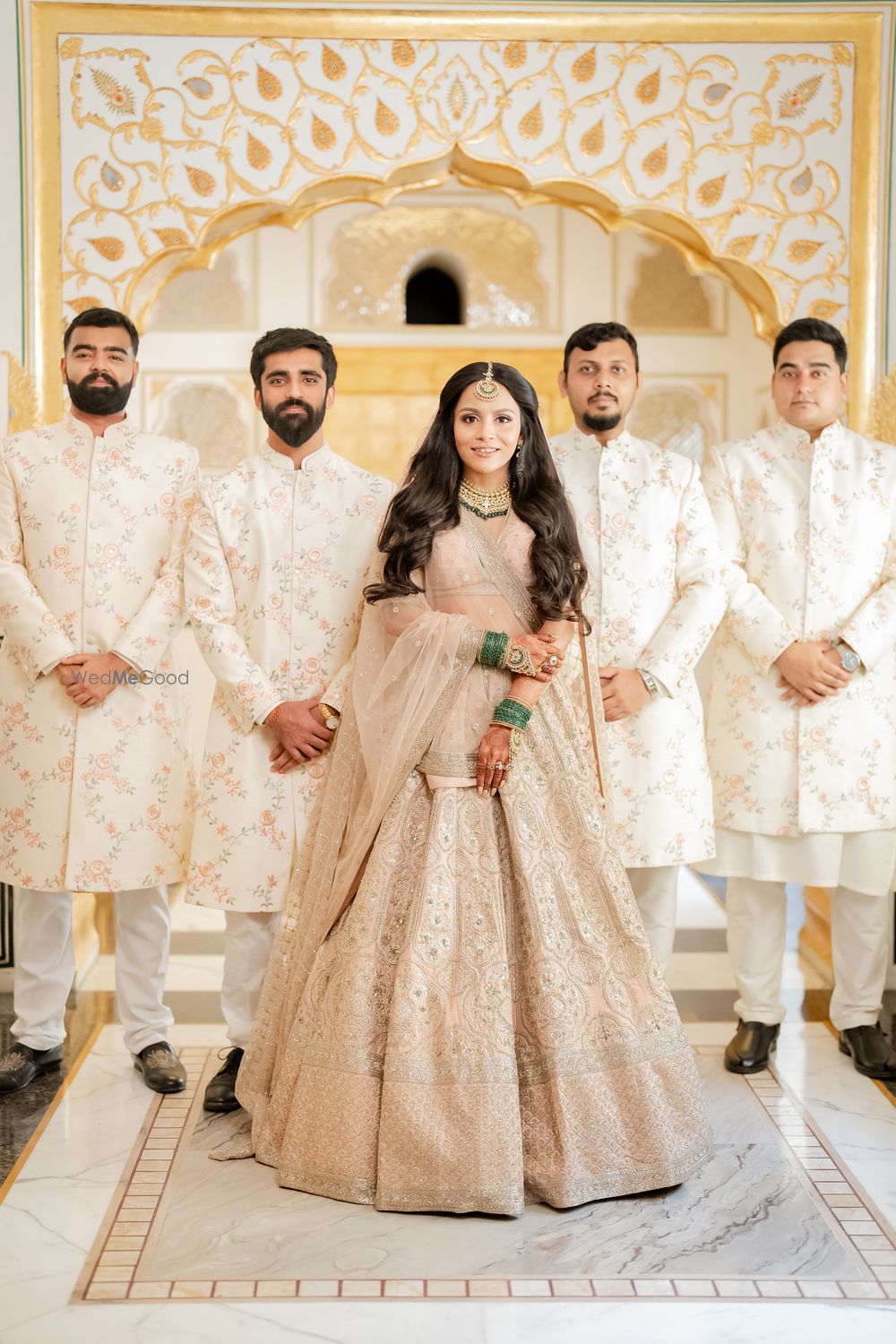 Photo of bride with bridesmen all wearing pastels