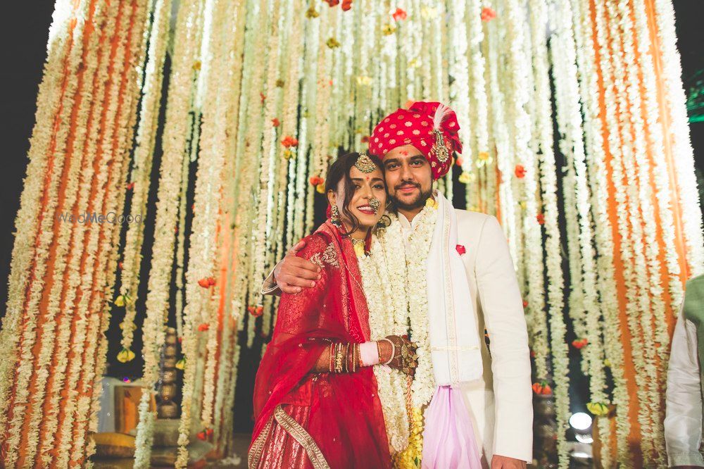 Photo of Wedding day couple shot against floral backdrop