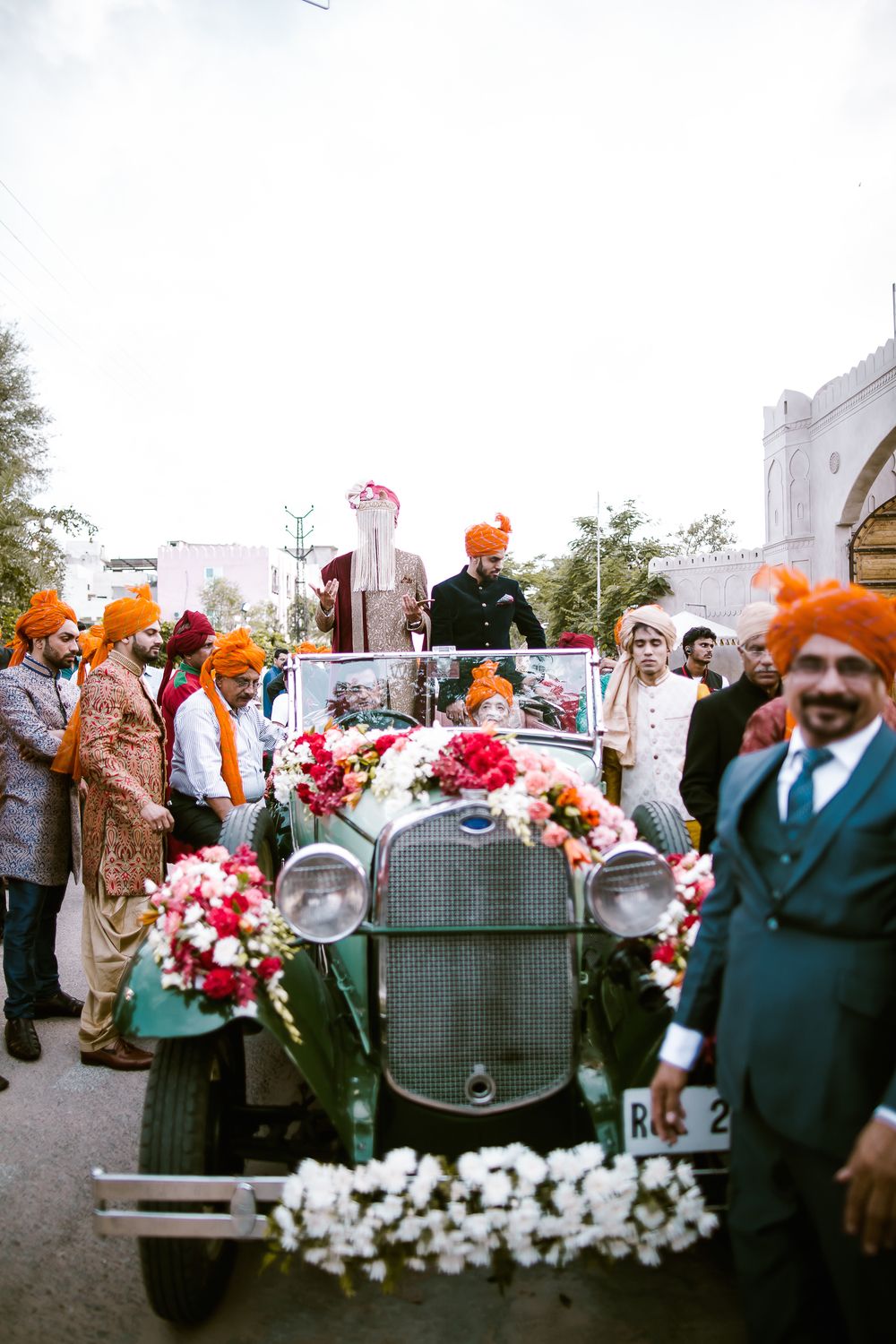 Photo of Groom entering in a vintage car for destination wedding