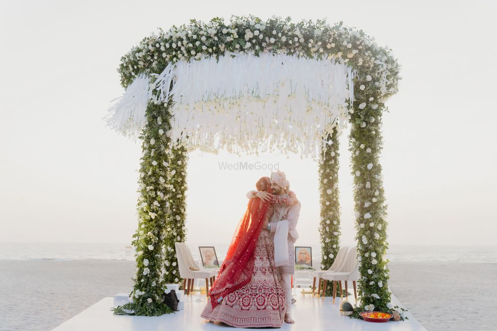 Photo of Gorgeous just married shot of the bride and groom hugging under a lovely outdoor circular mandap