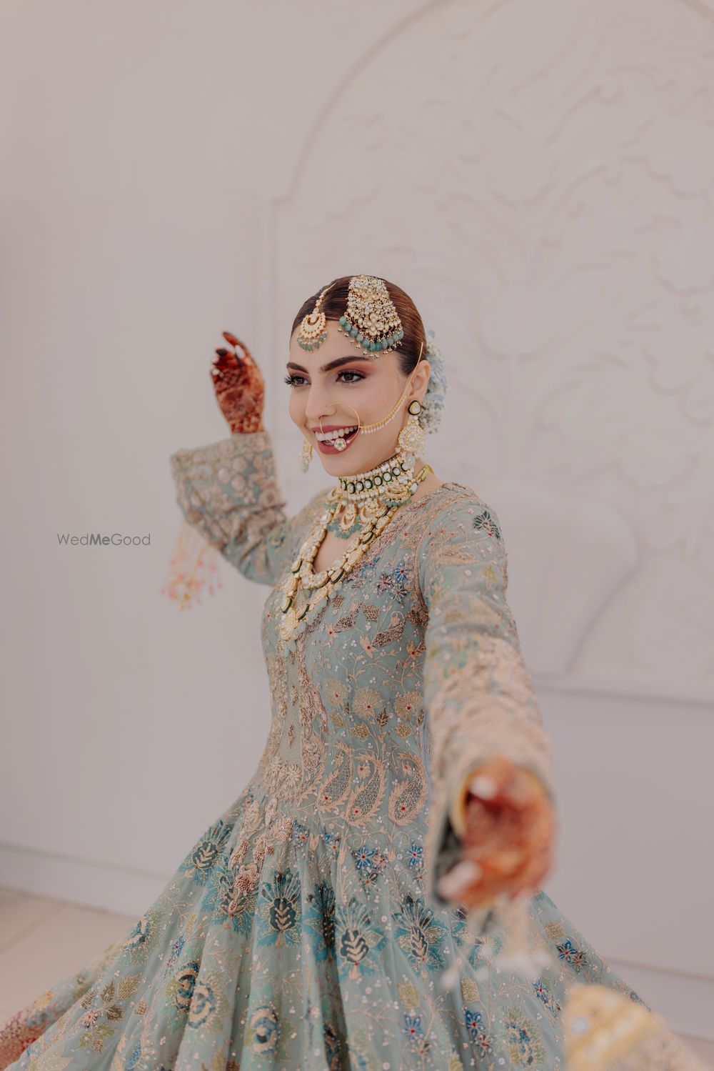 Photo of Bridal portrait on her wedding day in a stunning sea green pastel lehenga and heavy diamond and emerald jewellery