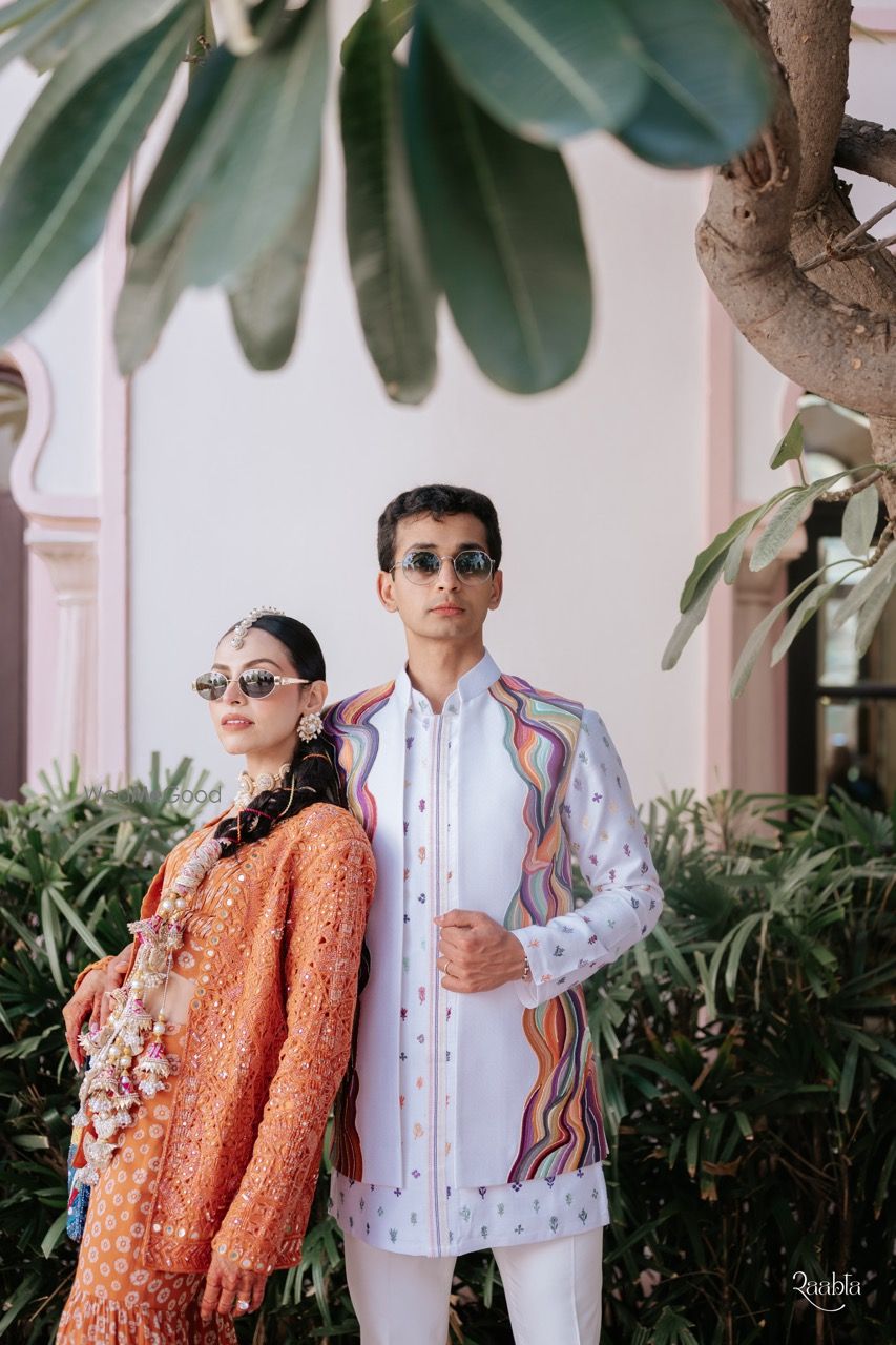 Photo of Couple portrait on mehendi day with bride in a cape outfit and gold parandi look