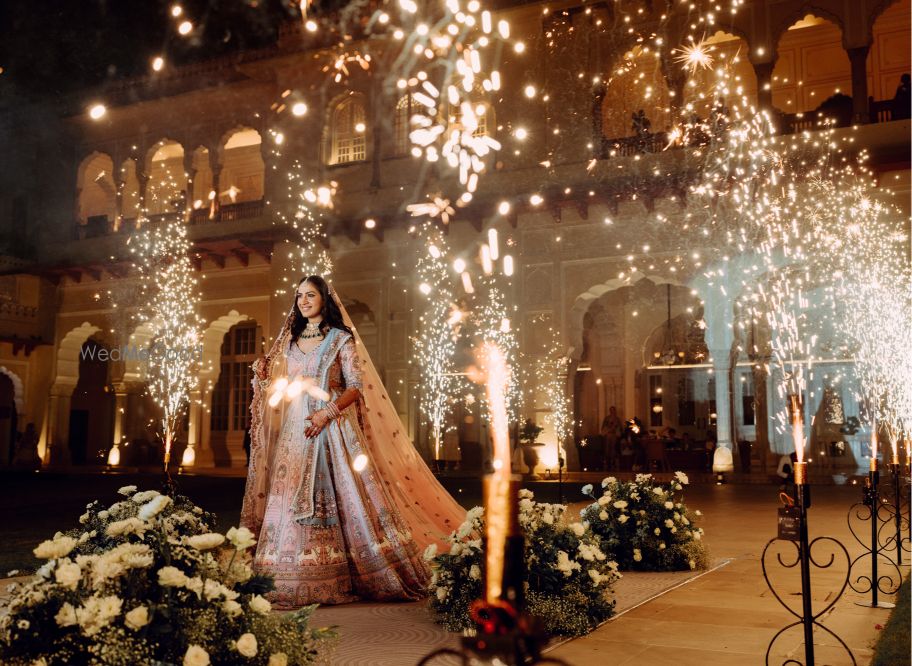 Photo of Lovely shot of the bride entering amidst fireworks for her wedding day in a pastel lehenga