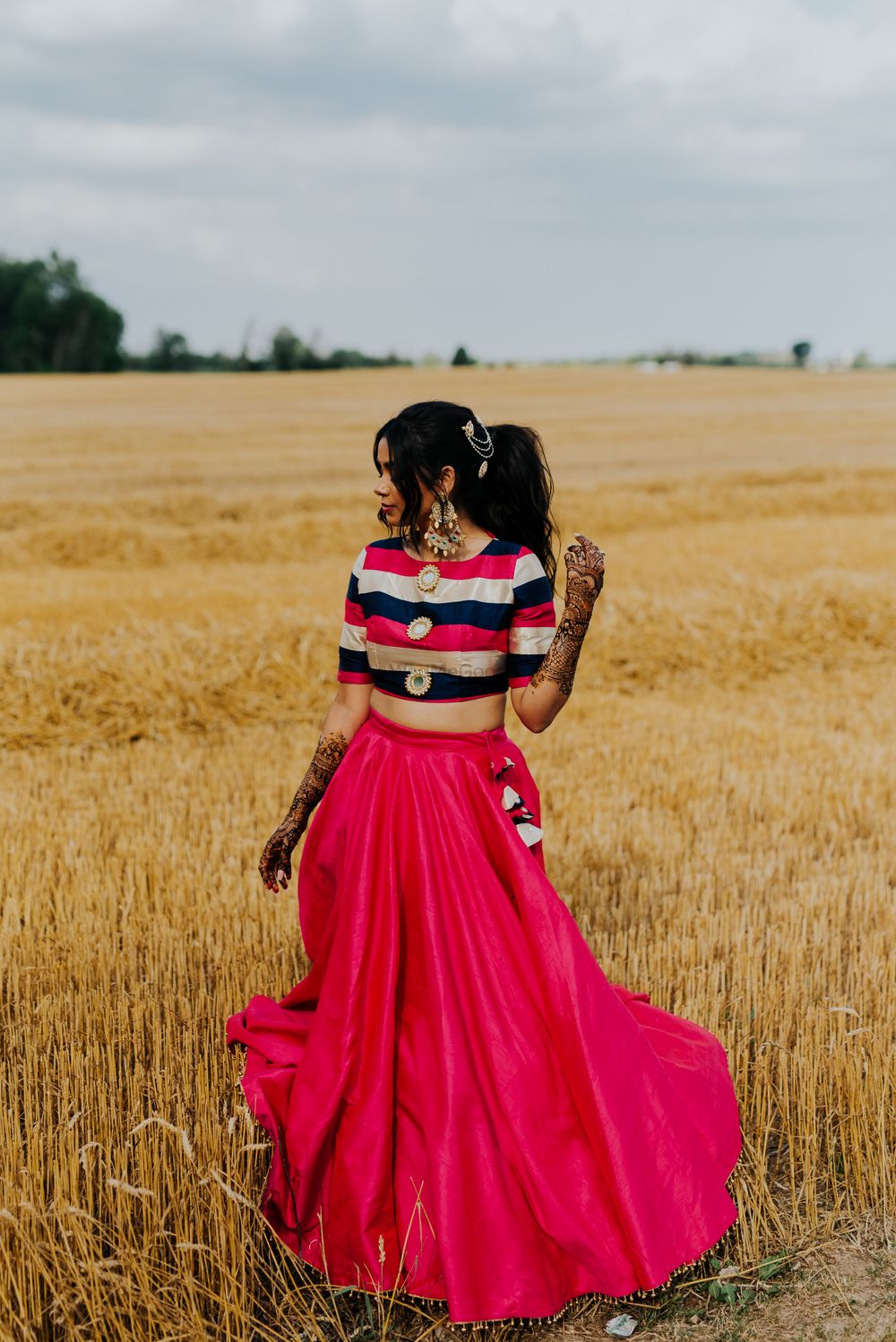 Photo of The bride dressed in a crop top and skirt for her mehendi shoot.