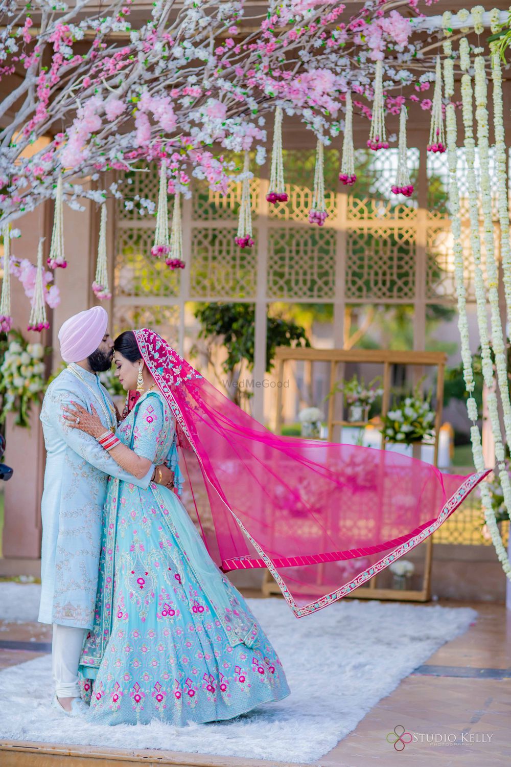 Photo of sikh bride and groom in powder blue outfits matching with decor