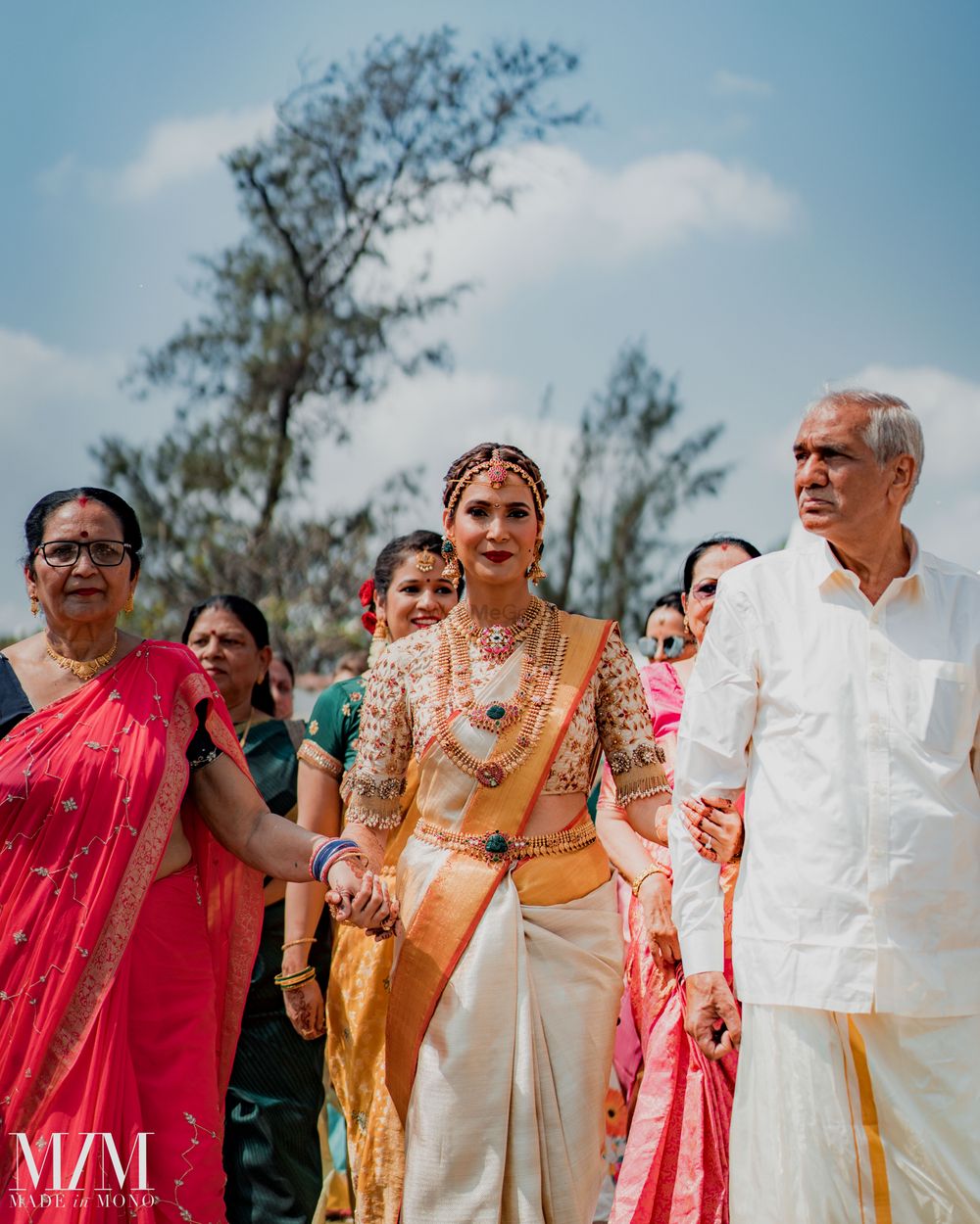 Photo of bride entering wedding with her parents for south indian wedding