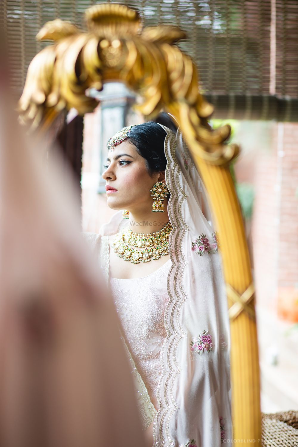 Photo of bride looking in mirror wearing scalloped dupatta