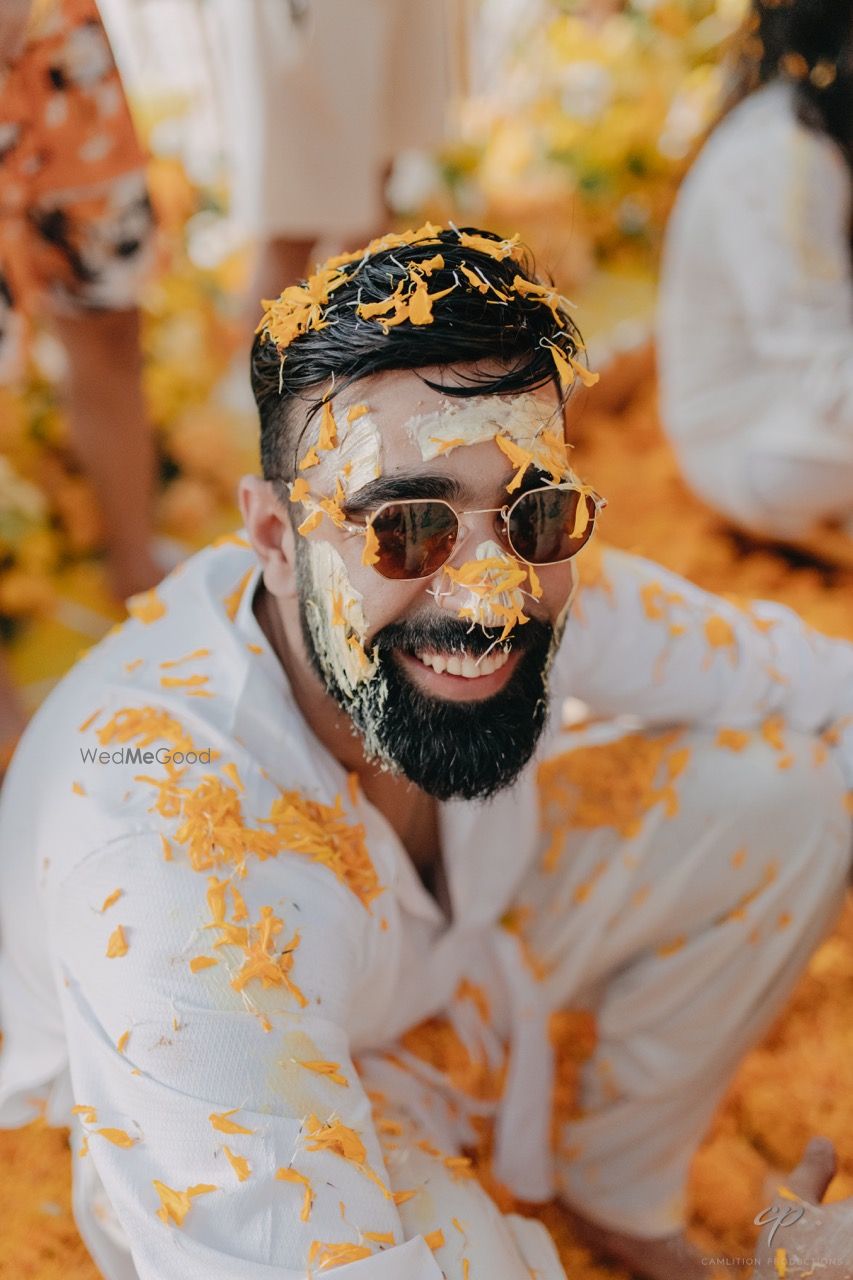 Photo of Fun haldi photo of the groom with yellow flowers on haldi day