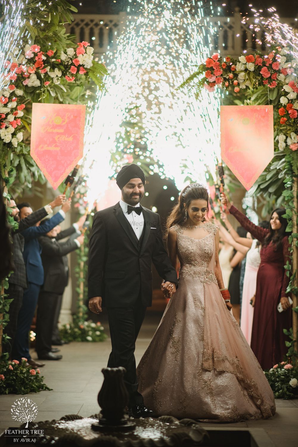 Photo of Bride and groom reception entry idea with guests holding cold pyros