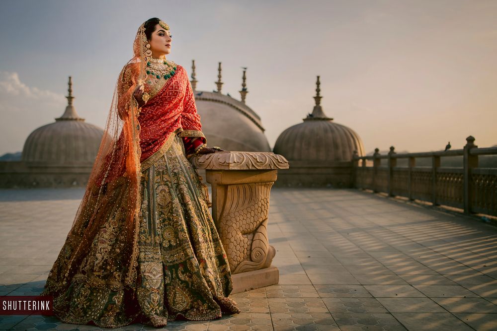 Photo of A bride dressed in green and red lehenga on her wedding day
