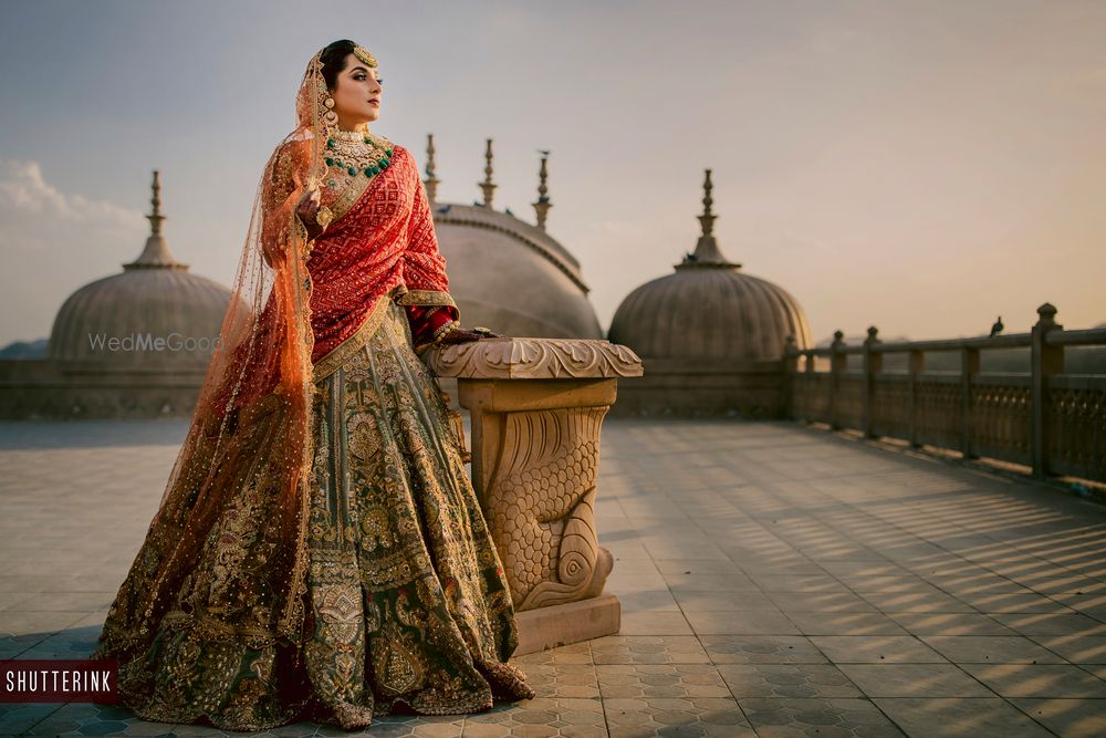 Photo of A bride dressed in green and red lehenga on her wedding day