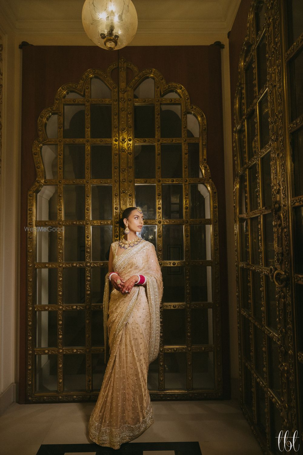 Photo of Timeless bridal portrait in bride in a sleek bun, statement jewellery and a monotone champagne gold saree