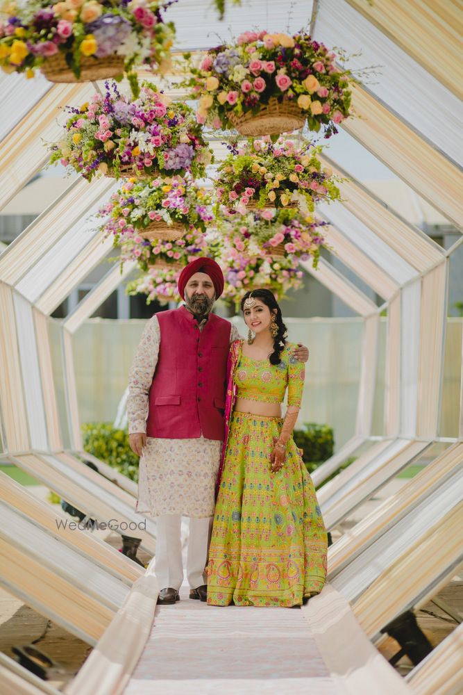 Photo of Bride posing with father on mehendi