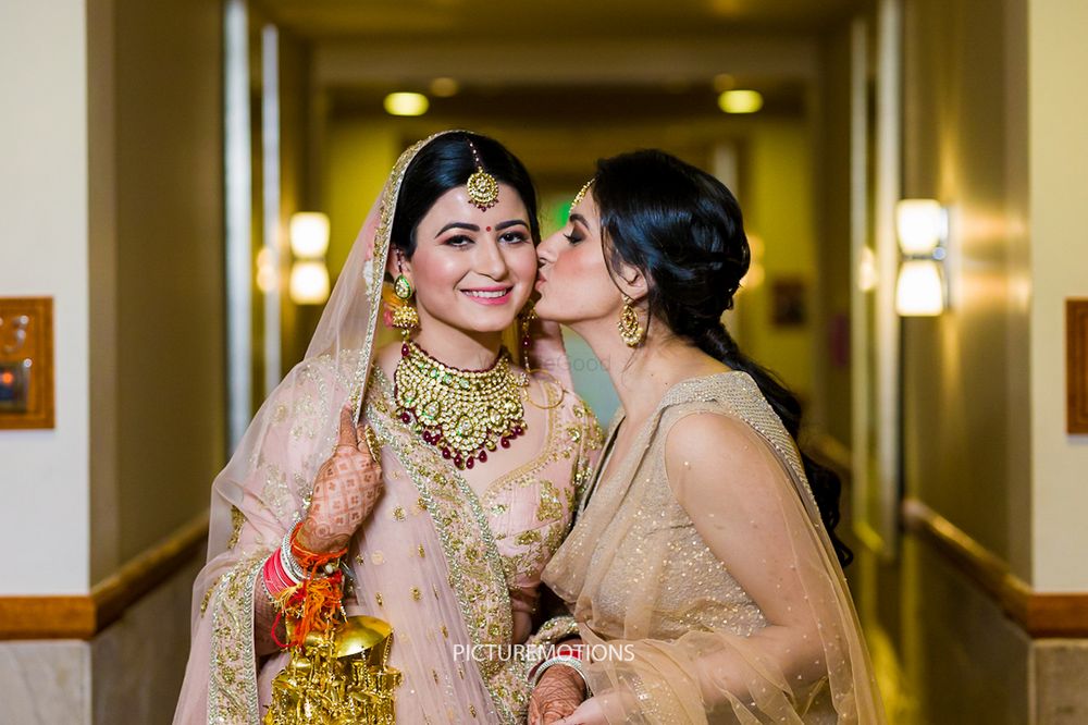 Photo of Bride with sister kissing her