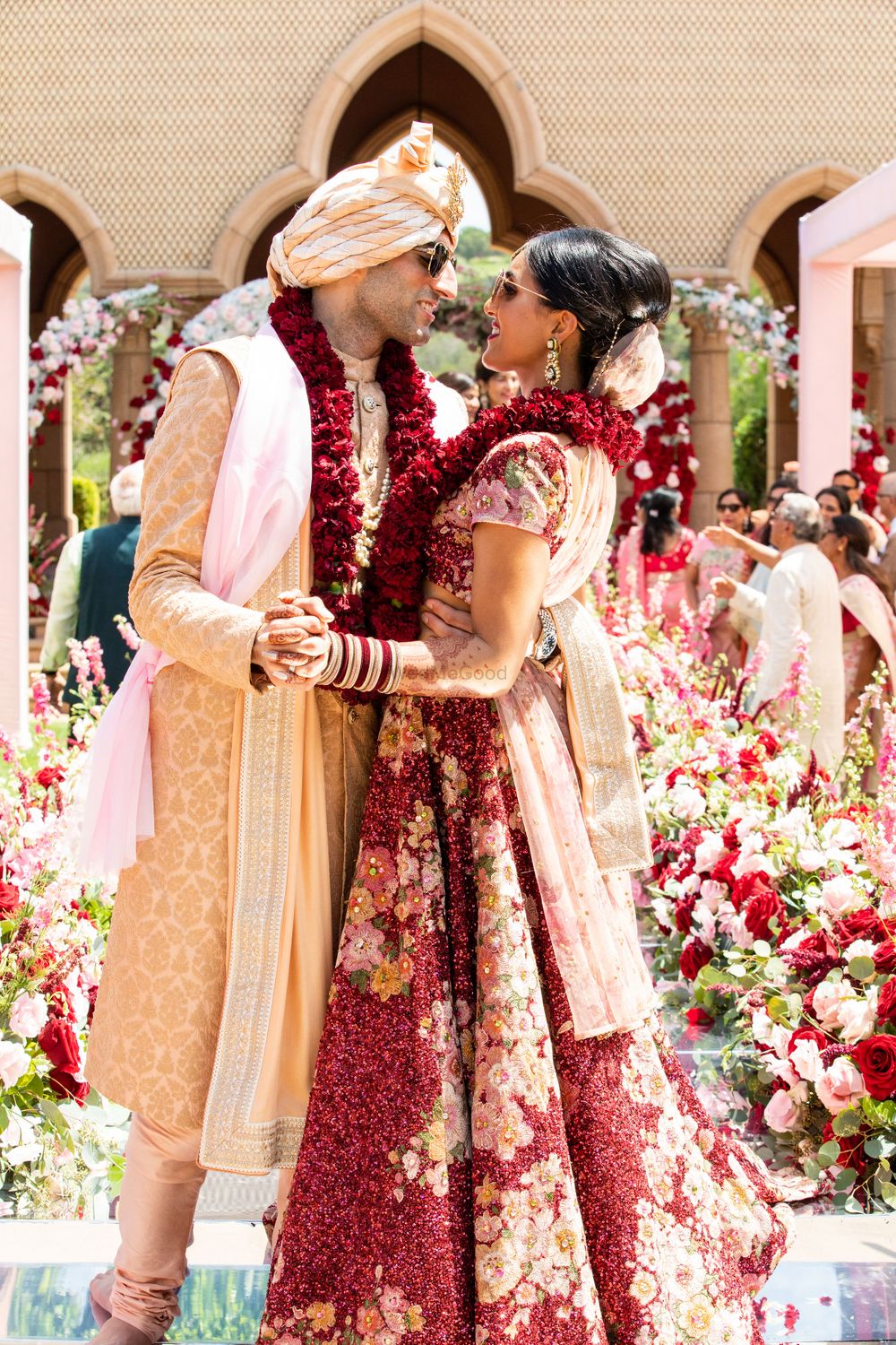 Photo of cute couple shot post pheras wearing maroon jaimalas matching decor