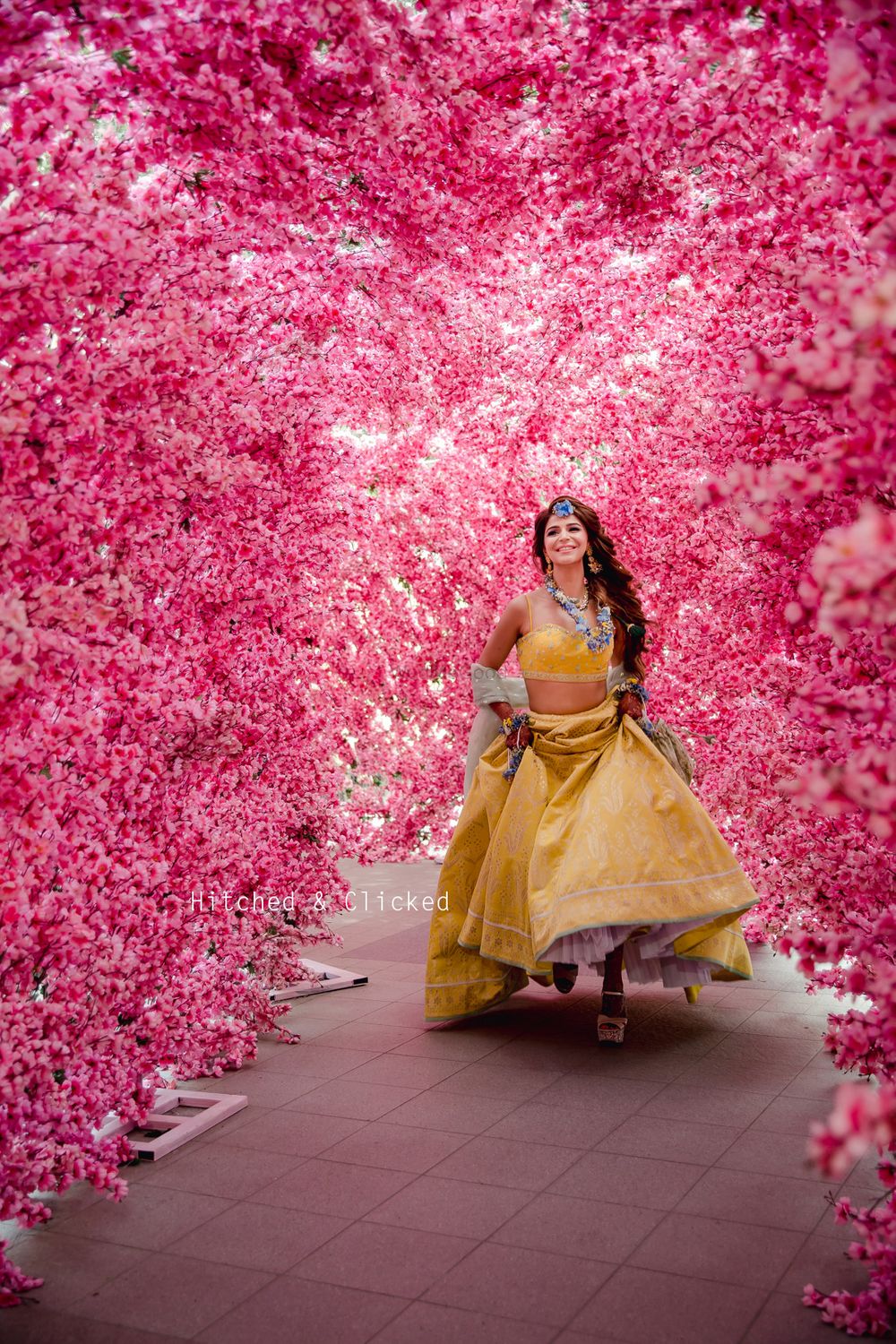Photo of A bride in a yellow lehenga for her mehndi with floral jewellery