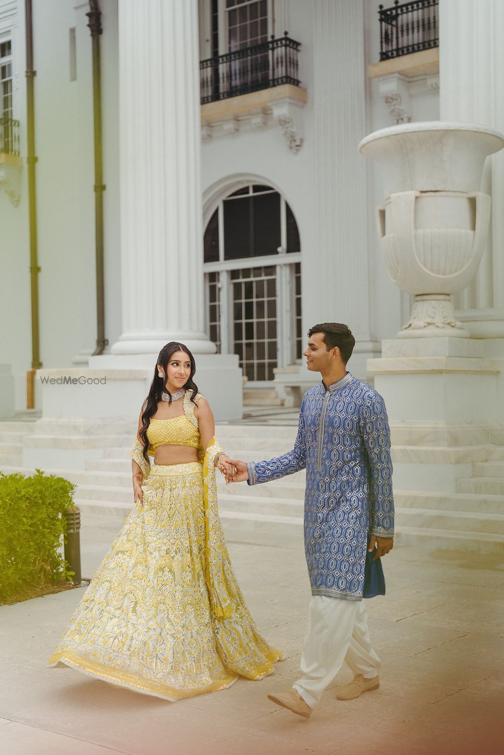 Photo of Bride in a yellow lehenga with white work and groom in a fresh blue kurta for their mehendi