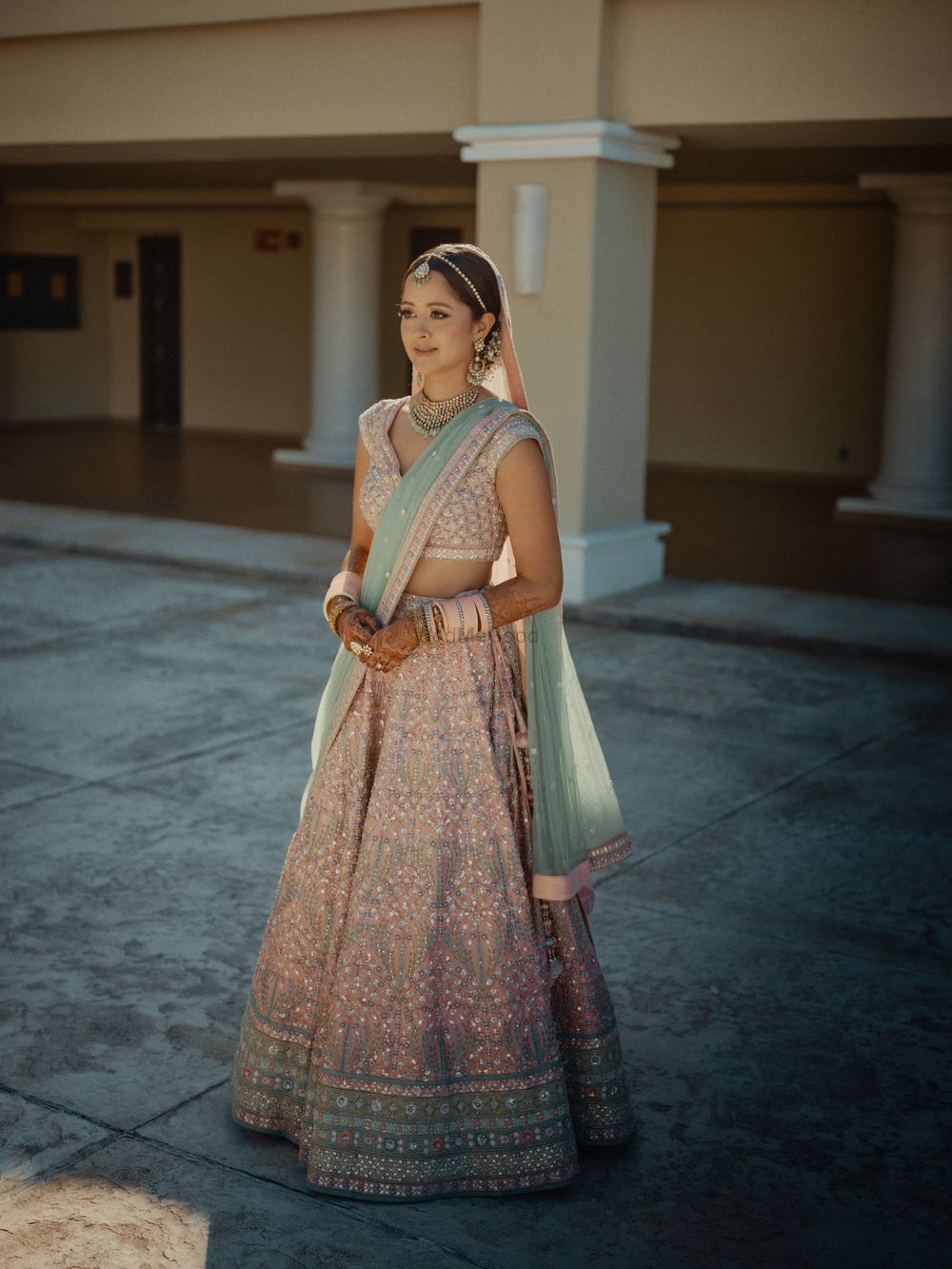 Photo of bride in a pretty pastel anita dongre lehenga with contrasting dupatta
