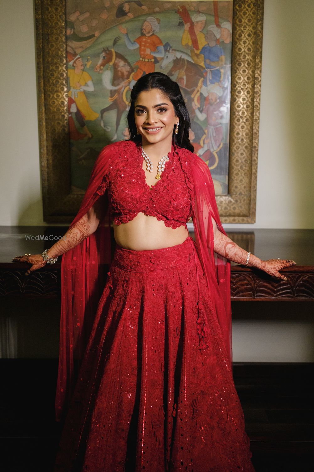 Photo of Fun all red lehenga for sangeet with topaz and diamond jewellery for the bride with a cape