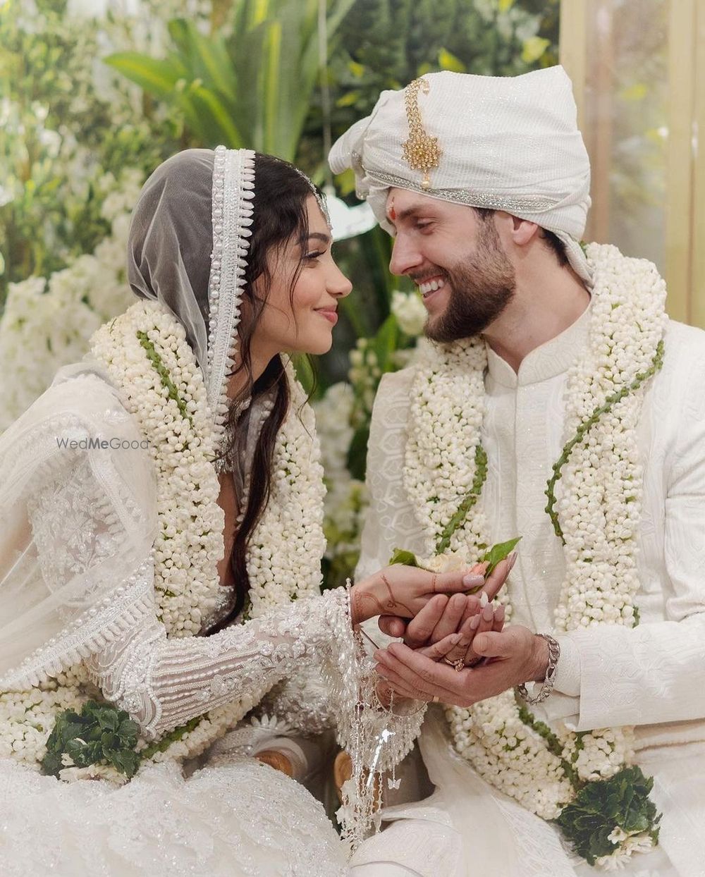 Photo of Alanna and Ivor in white custom Manish Malhotra outfits on their wedding day during varmala