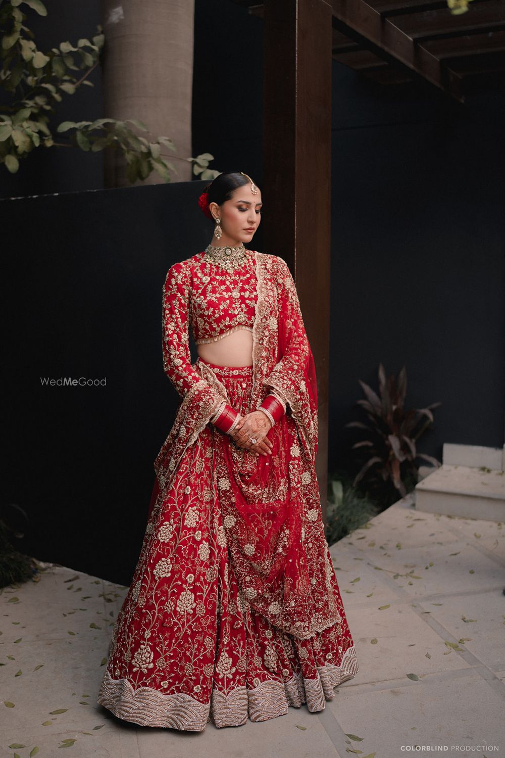 Photo of Stunning all-red lehenga with gold work, sleek hair bun and full sleeved blouse for the wedding day