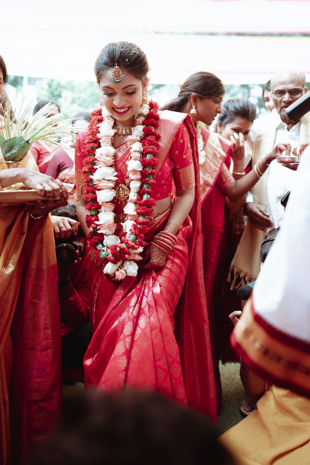 Photo of South Indian bride dressed in a red and gold saree on her wedding day.