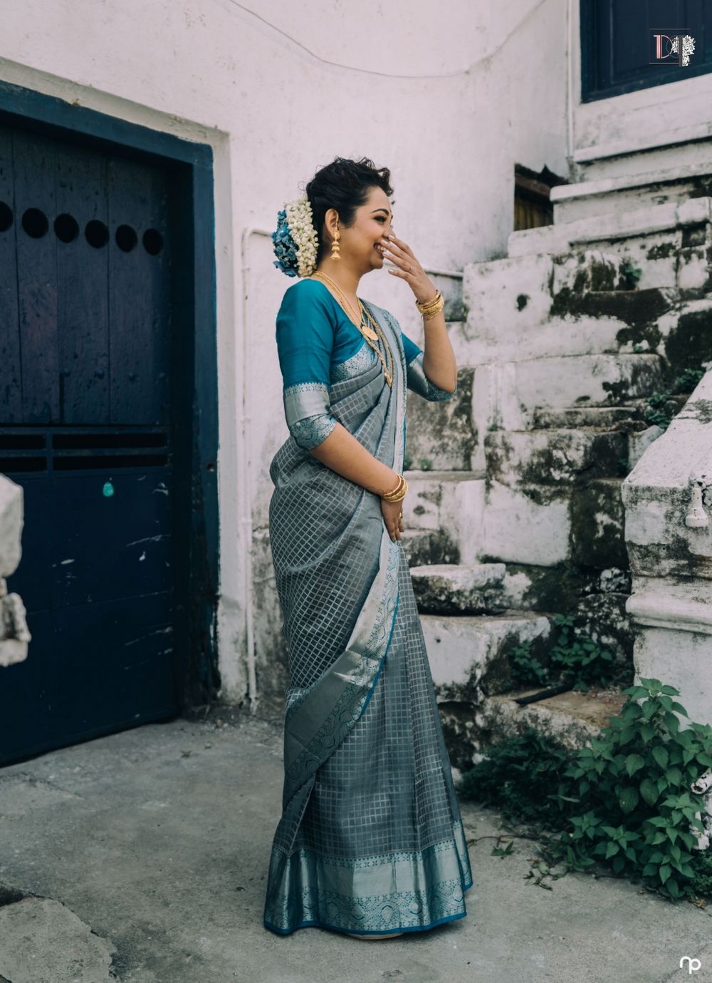 Photo of A beautiful bride in blue silk saree caught in a candid moment.
