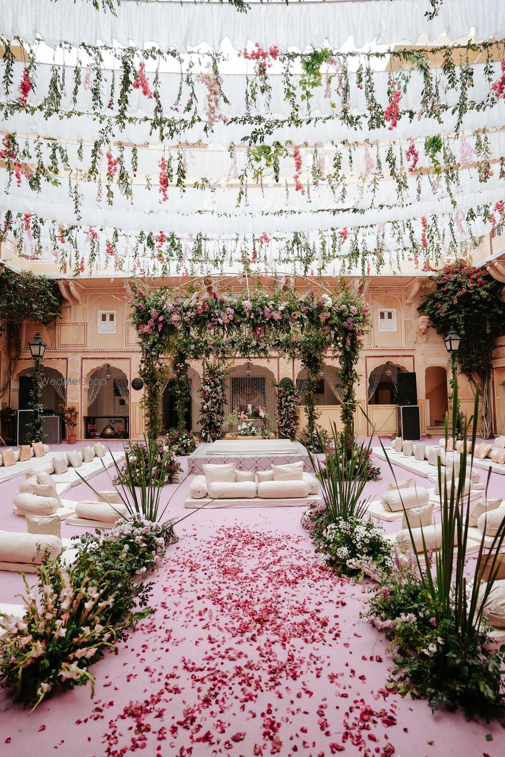 Photo of Gorgeous foliage and floral wedding mandap in an outdoor setting with pink floors