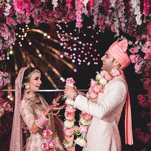 Photo of Matching bride and groom in happy jaimala shot