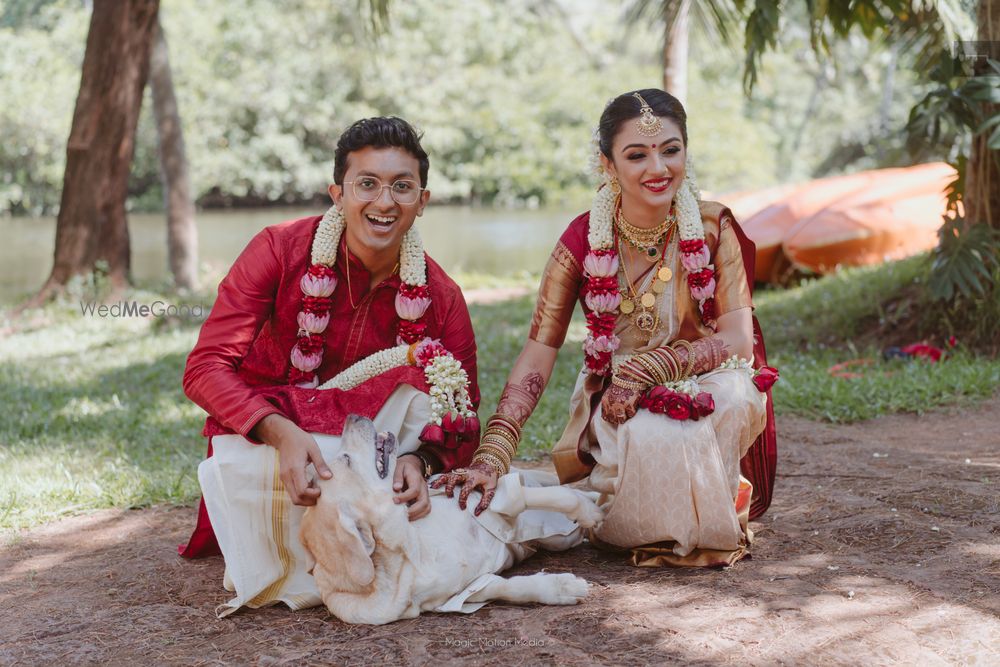 Photo of Birde and groom posing with their pet.