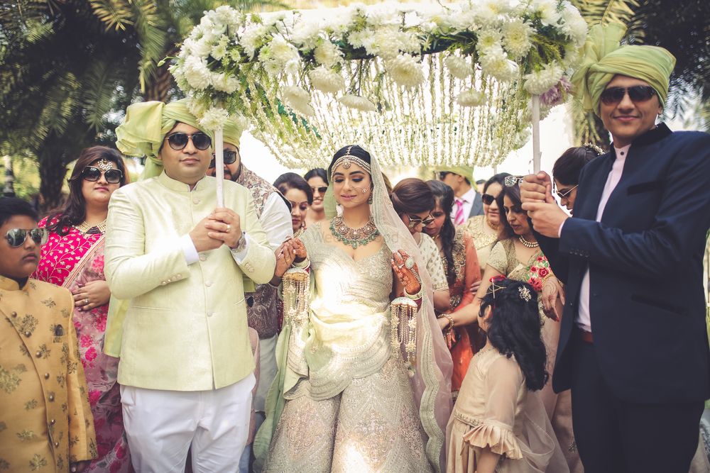 Photo of A gorgeous bridal entry with the bride under a white phoolon ki chaadar