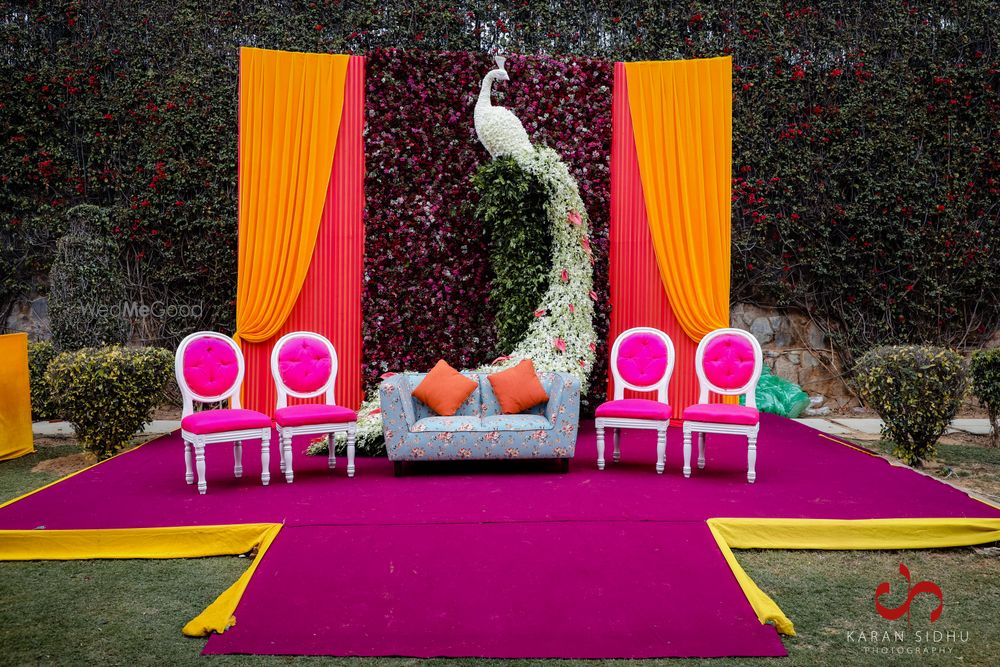 Photo of mehendi stage backdrop with peacock prop