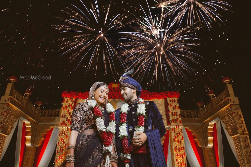 Photo of A couple poses infront of fireworks on their wedding day