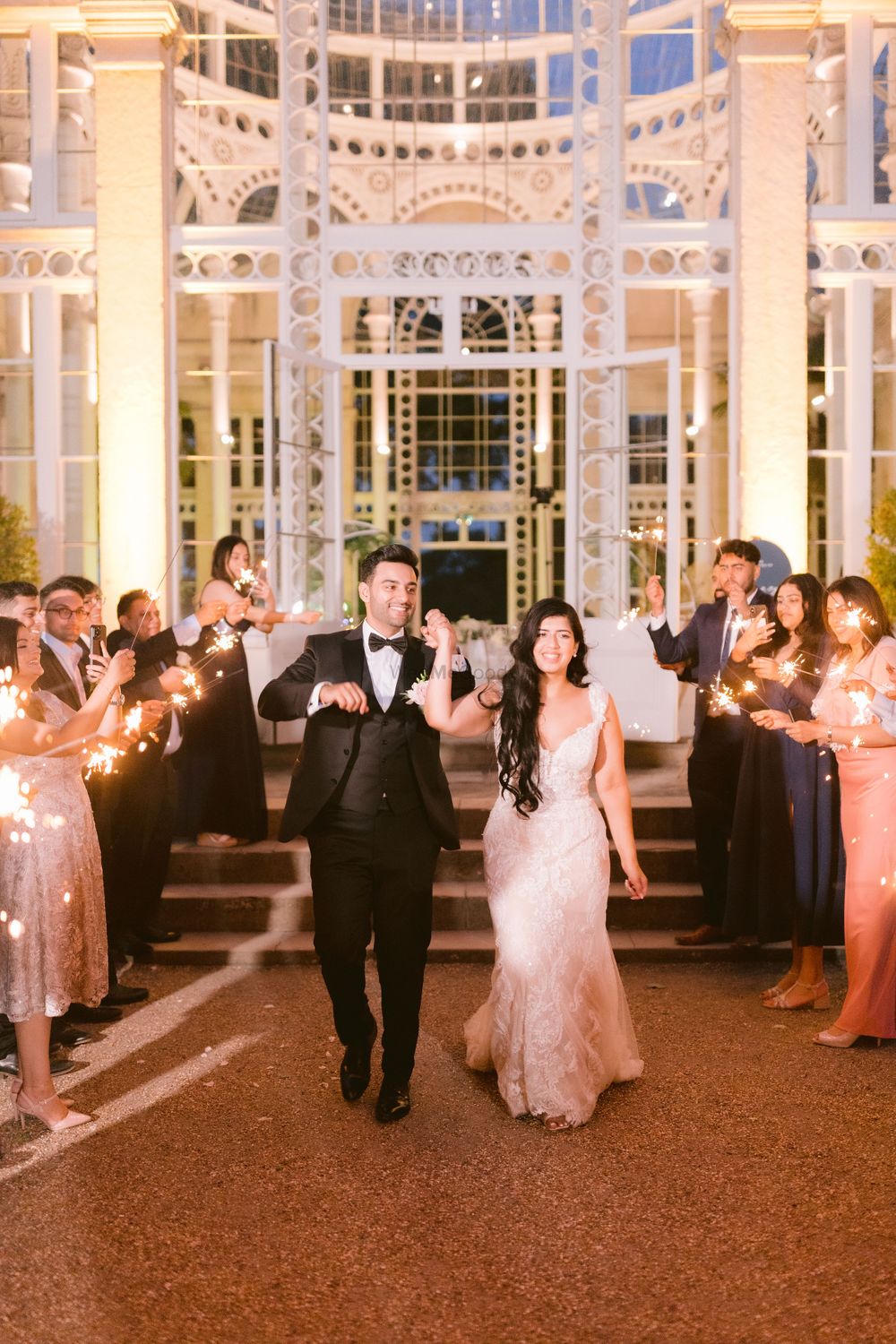 Photo of couple entry photo with guest holding sparklers