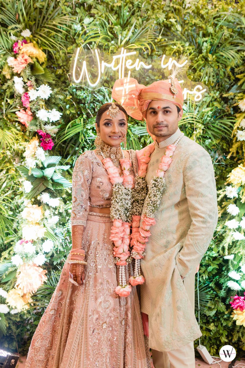 Photo of matching bride and groom in peach with babys breath jaimala