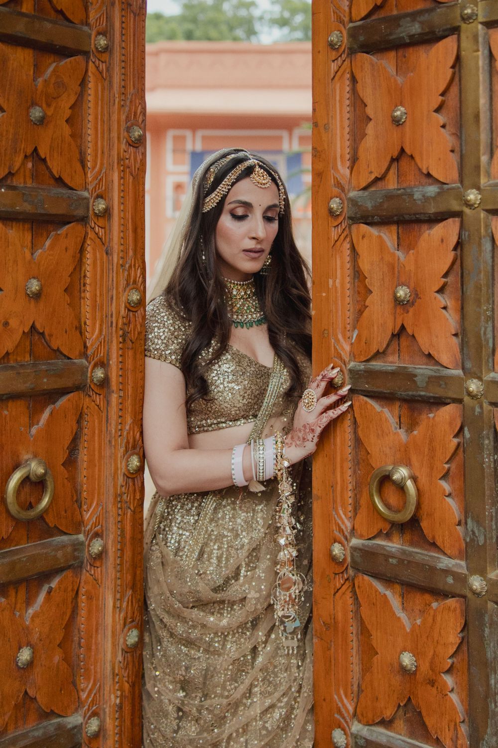 Photo of Classic bridal portrait with bride in a all-gold lehenga with shimmer details