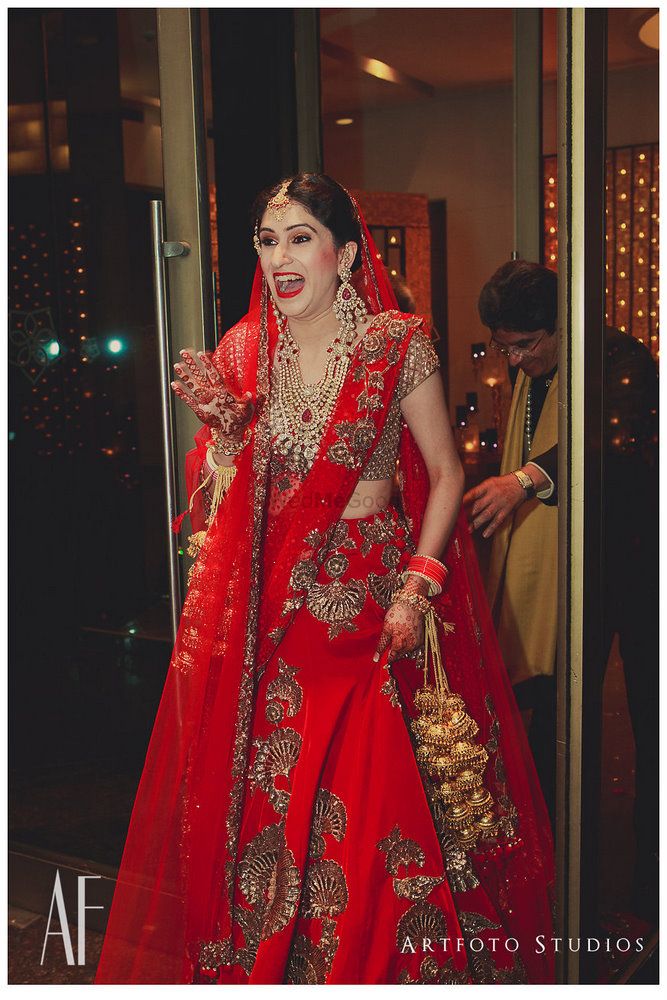 Photo of Bride in red bridal lehenga by Manish Malhotra