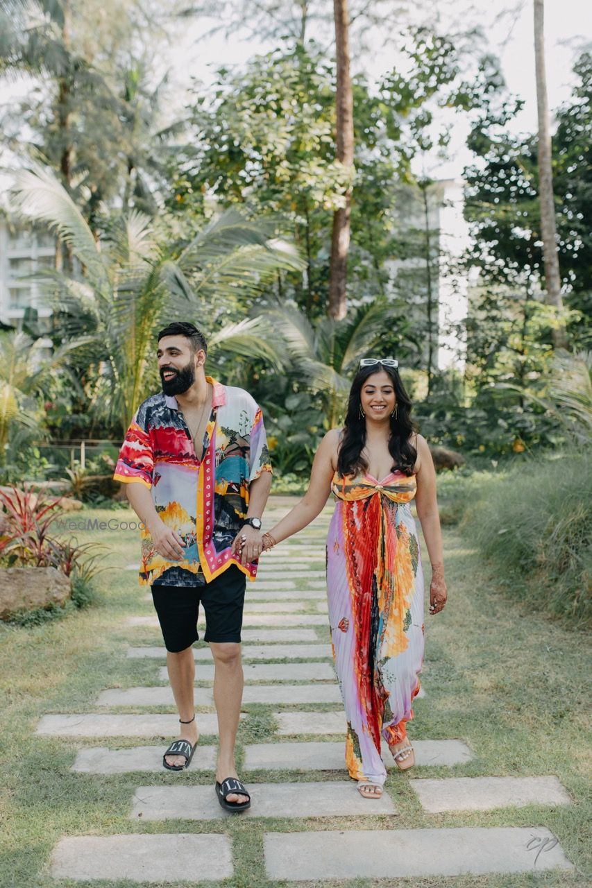 Photo of Casual couple entry idea with the couple wearing matching colourful outfits for the pool party