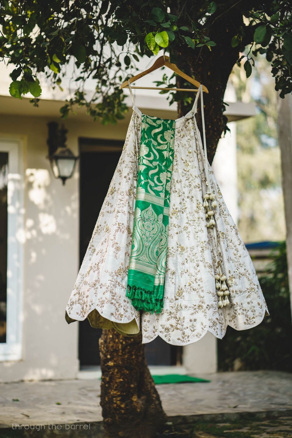 Photo of Off white lehenga on hanger with contrasting benarasi dupatta