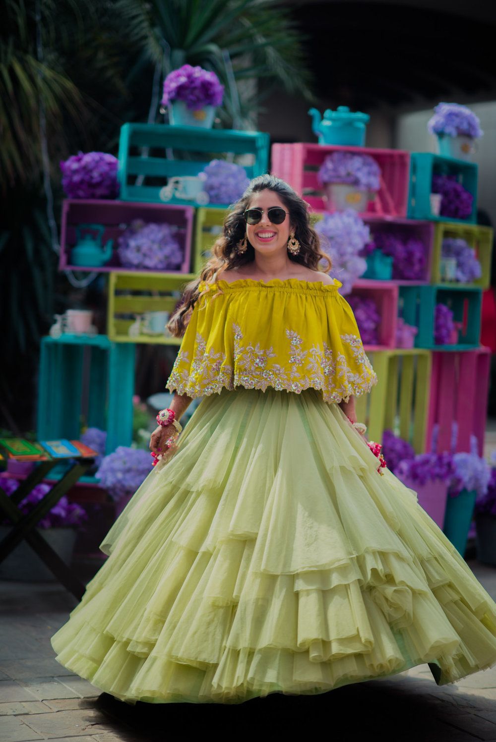 Photo of Twirling bride in mustard off shoulder blouse with frill skirt for mehendi