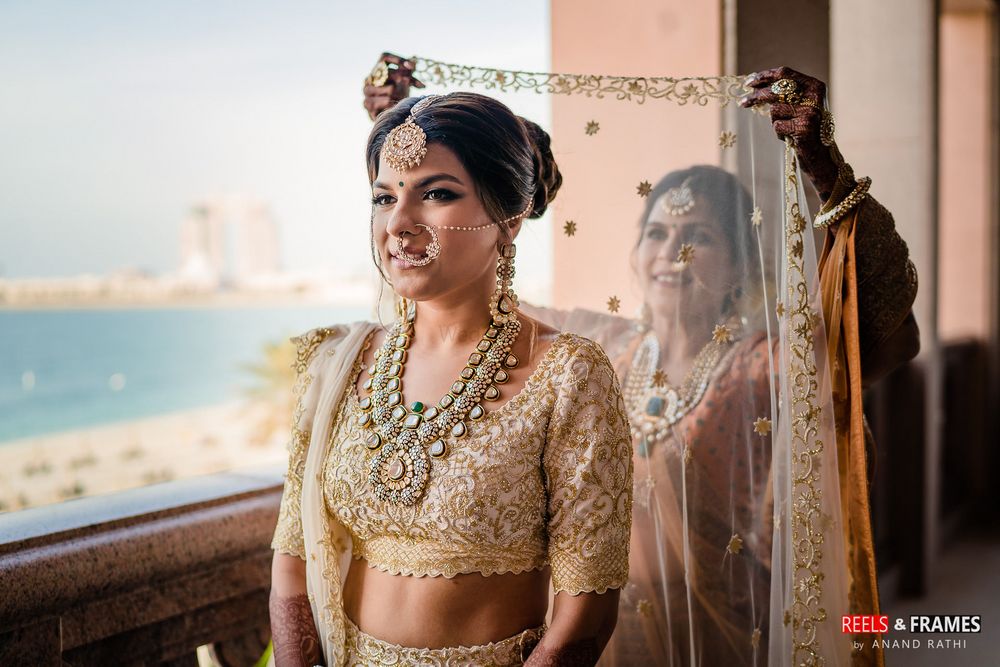 Photo of Mother of the bride placing the dupatta on her daughter's head