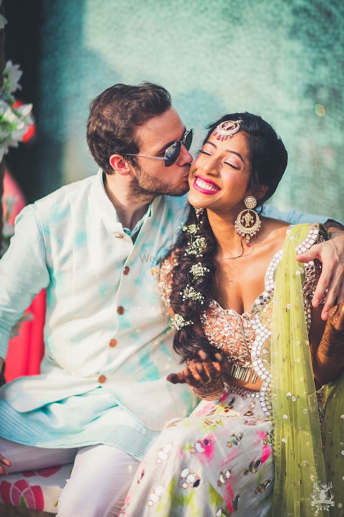 Photo of Mehendi couple portrait groom kissing bride shot
