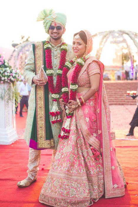 Photo of Pink and gold bridal lehenga worn as contrast to groom