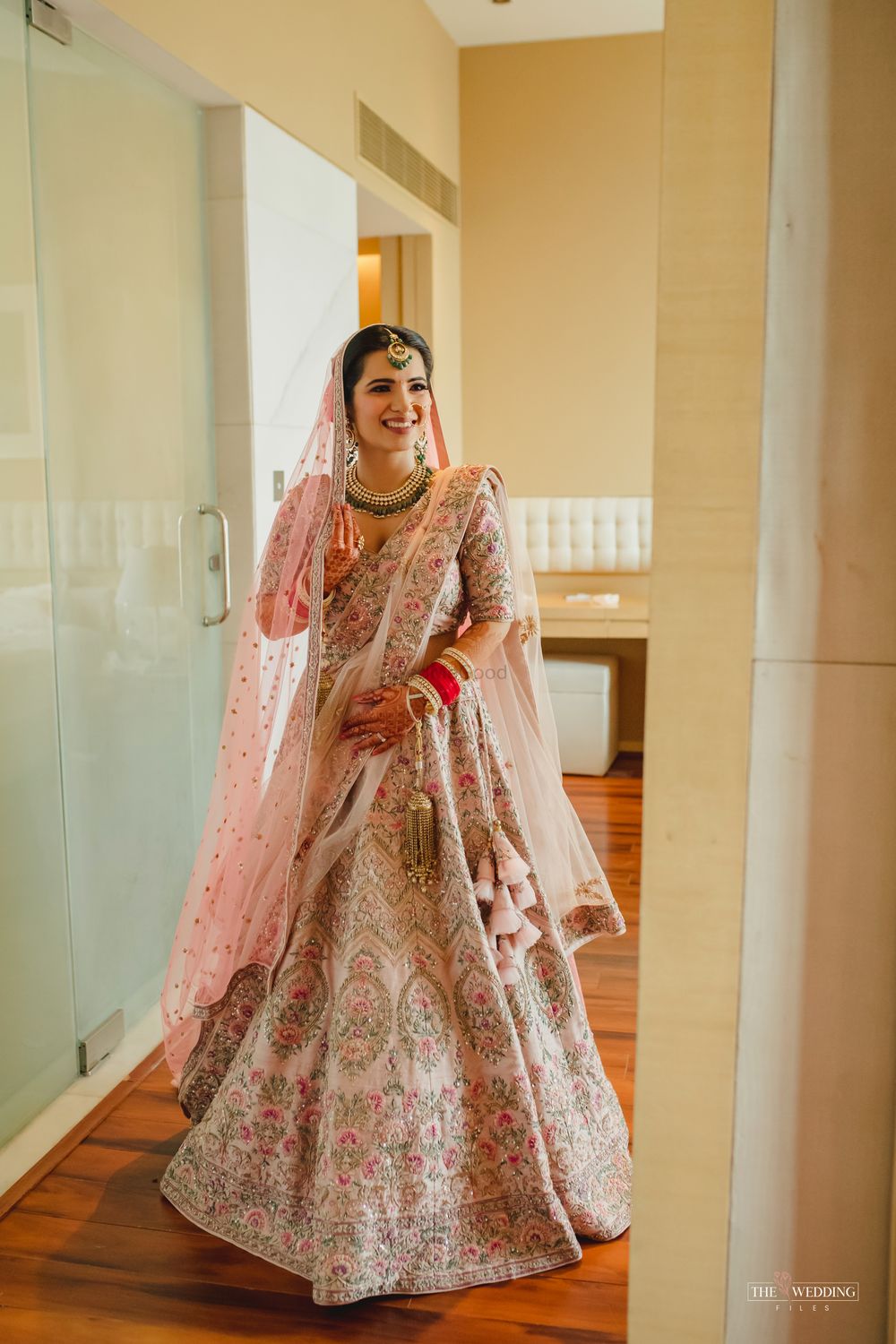 Photo of Bride dressed in a baby pink lehenga