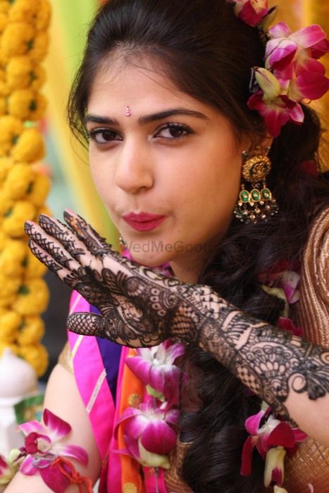 Photo of briaded hairstyle with floral porchid in hair mehendi hairstyle