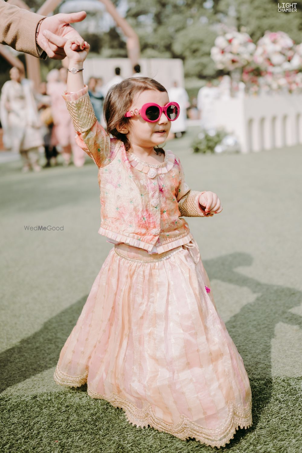 Photo of sweet kid dancing in peach lehenga