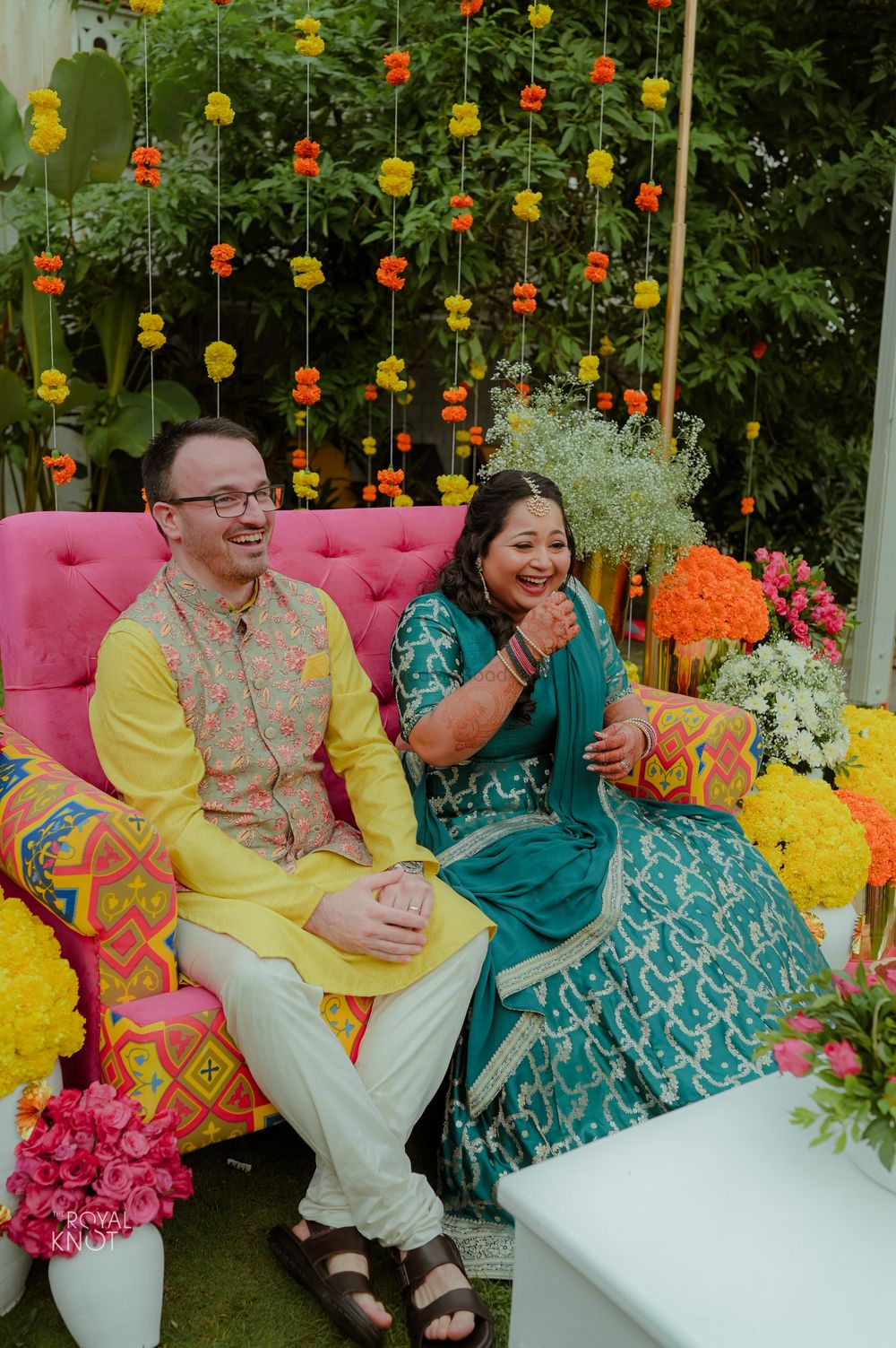 Photo of cute couple portrait against colourful mehendi backdrop