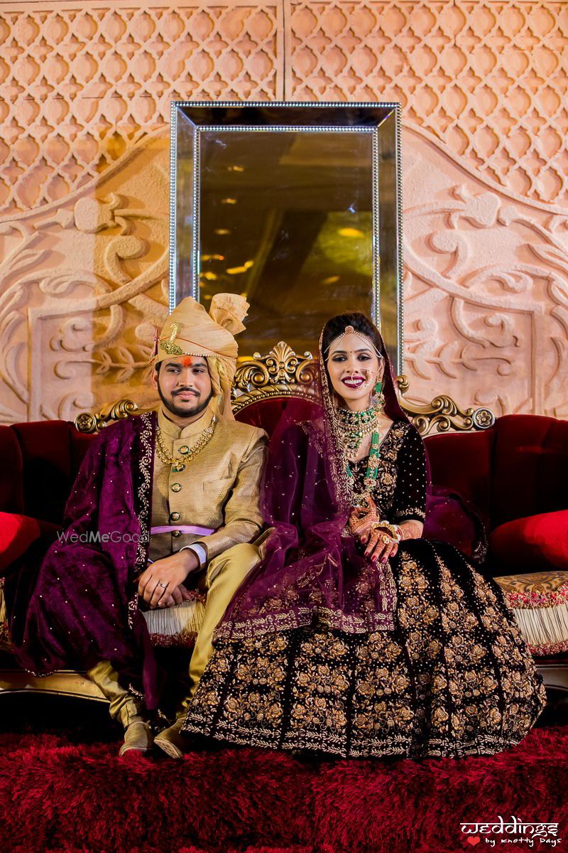 Photo of Matching bride and groom in purple velvet lehenga